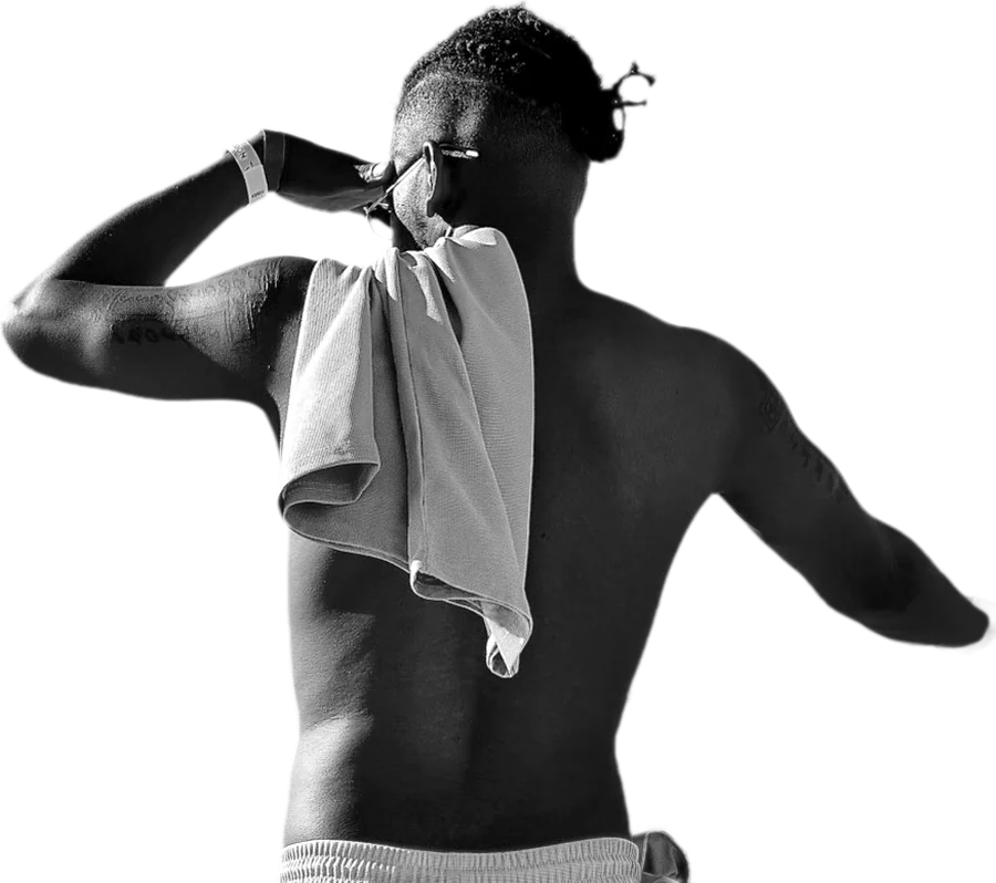 Portrait d'Anthony Ndekina Elibo de dos, en noir et blanc, une serviette sur l'épaule.